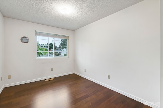 spare room with dark hardwood / wood-style flooring and a textured ceiling