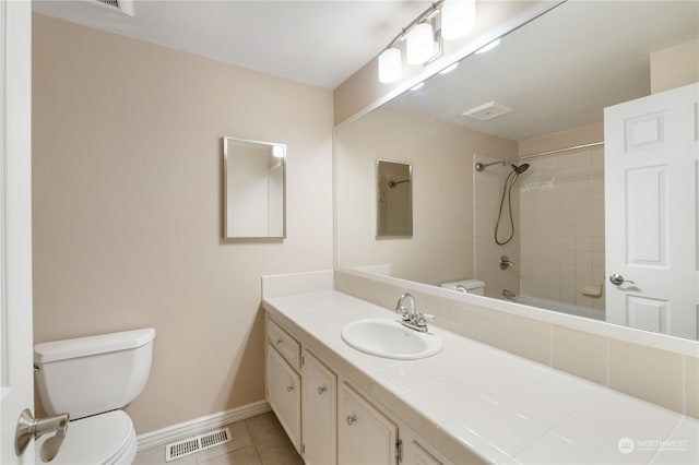 full bathroom with tiled shower / bath, tile patterned flooring, vanity, and toilet