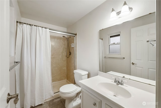 bathroom with tile patterned floors, toilet, vanity, and walk in shower