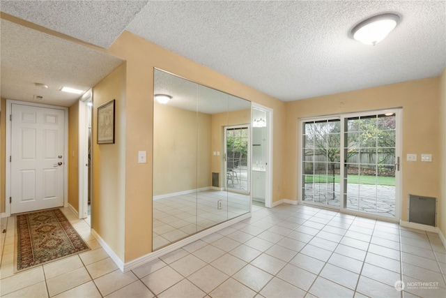 entryway featuring light tile patterned floors and a textured ceiling