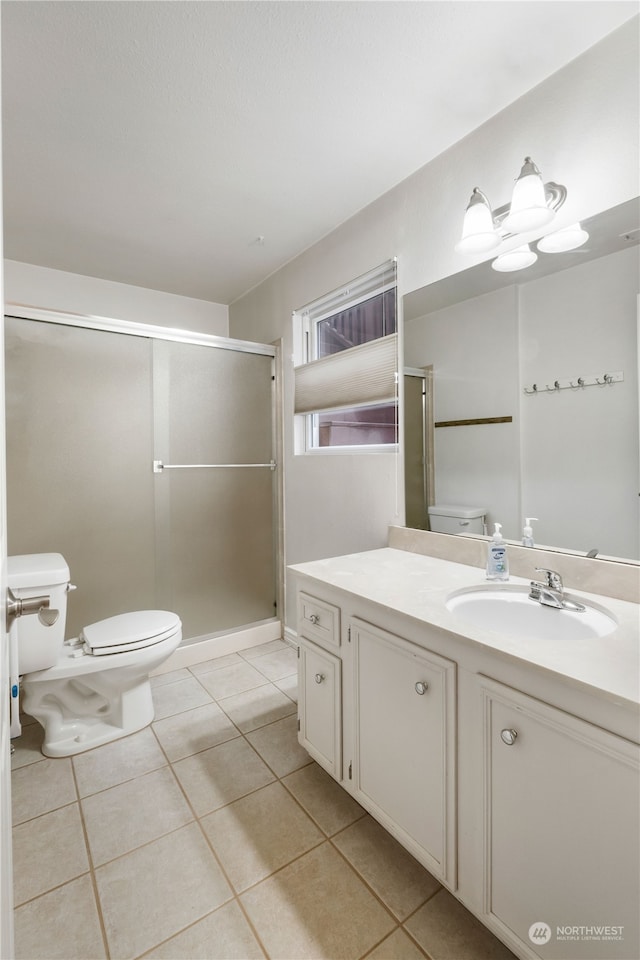 bathroom with toilet, vanity, tile patterned floors, and an enclosed shower