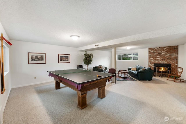 rec room featuring a fireplace, carpet, and a textured ceiling