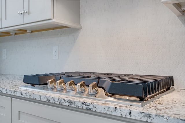 room details with stainless steel gas stovetop and white cabinets