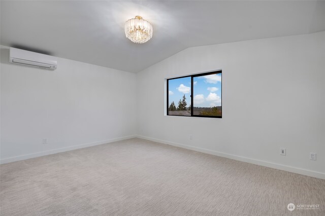 empty room with vaulted ceiling, light carpet, a wall unit AC, and a notable chandelier