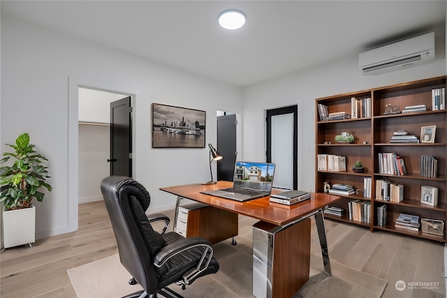 office space featuring a wall mounted air conditioner and light hardwood / wood-style flooring