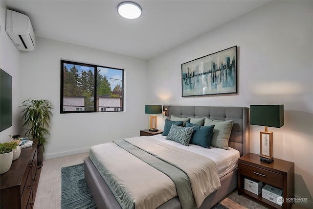 bedroom featuring a wall mounted AC and light wood-type flooring