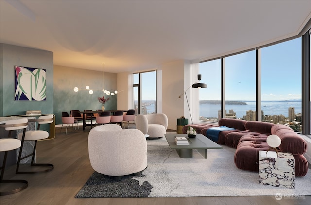 living room featuring hardwood / wood-style floors, a water view, floor to ceiling windows, and a notable chandelier