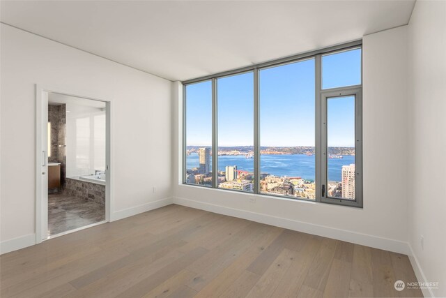 spare room with light wood-type flooring and a water view