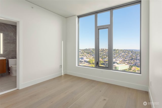 spare room with light hardwood / wood-style floors and tile walls