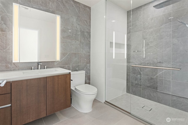 bathroom featuring a tile shower, tile patterned flooring, and tile walls