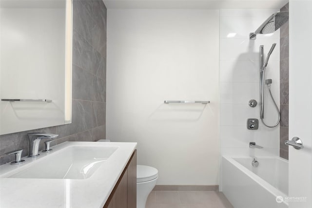 full bathroom featuring tiled shower / bath, tile patterned flooring, vanity, and toilet