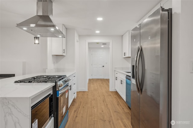 kitchen with white cabinetry, wall chimney range hood, and stainless steel appliances