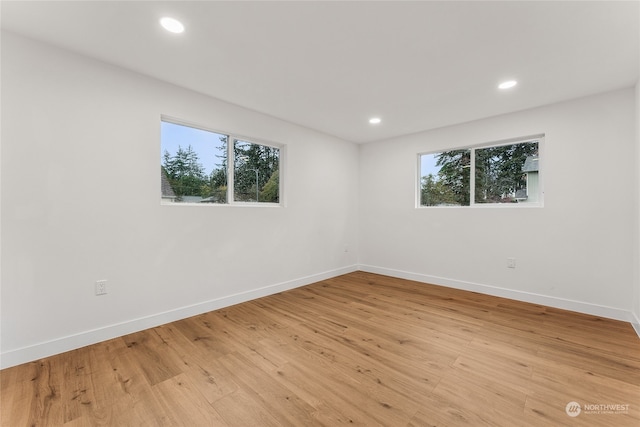 spare room with light wood-type flooring and a healthy amount of sunlight