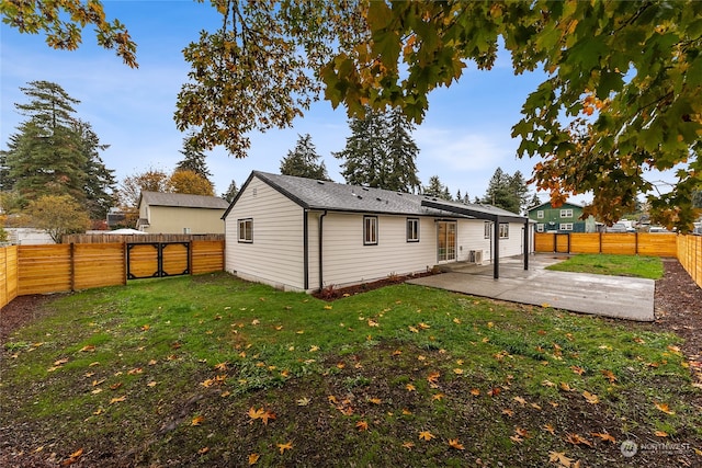 back of property with a lawn and a patio area