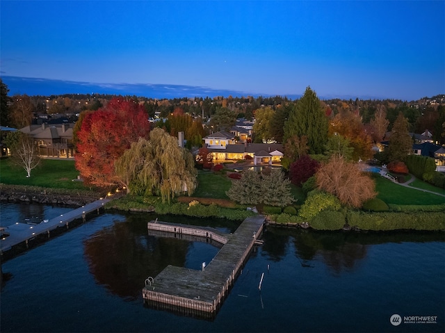 aerial view at dusk featuring a water view