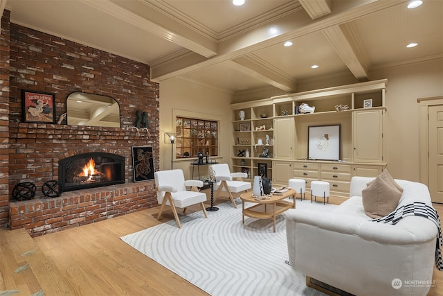 living room featuring beam ceiling, light hardwood / wood-style flooring, ornamental molding, and a brick fireplace