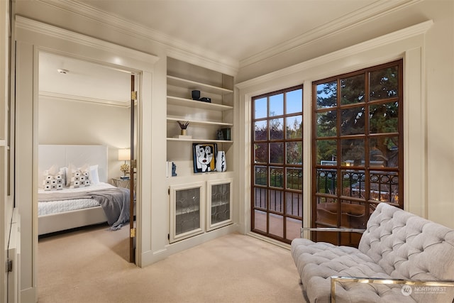 sitting room with crown molding and light colored carpet