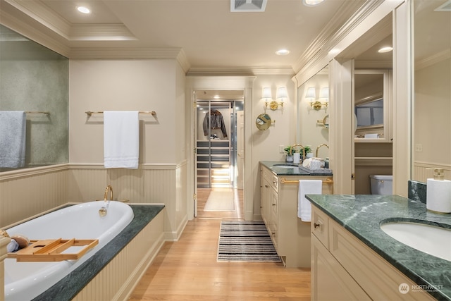 bathroom featuring a washtub, hardwood / wood-style floors, vanity, and crown molding