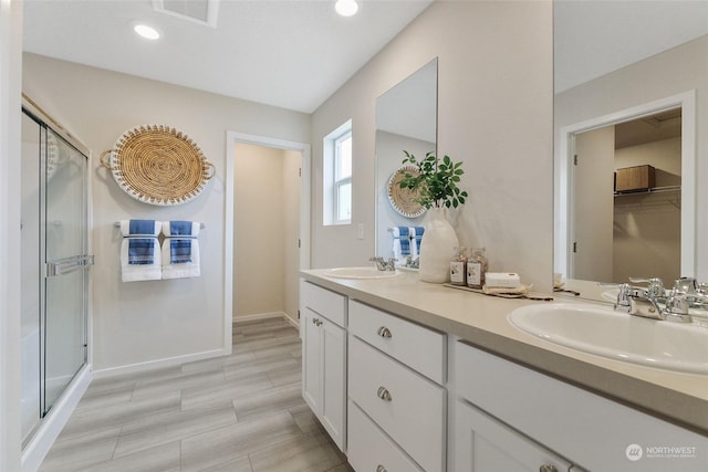 bathroom featuring vanity and a shower with door