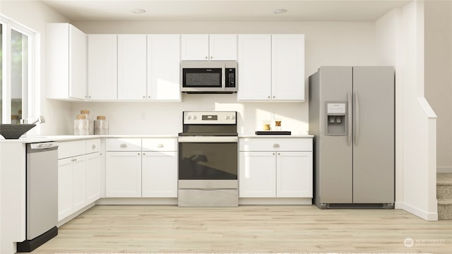 kitchen with stainless steel appliances, white cabinets, and light hardwood / wood-style floors