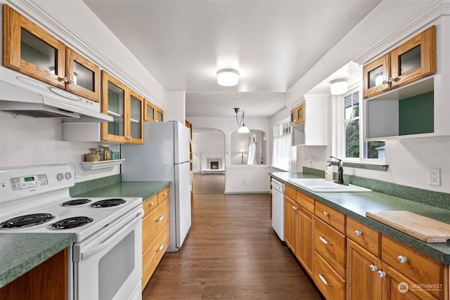 kitchen featuring a textured ceiling, white appliances, dark wood-type flooring, and sink