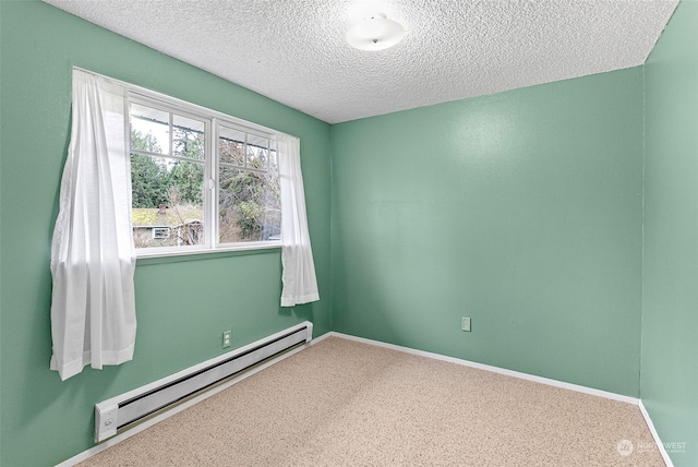 carpeted empty room featuring a textured ceiling and a baseboard heating unit