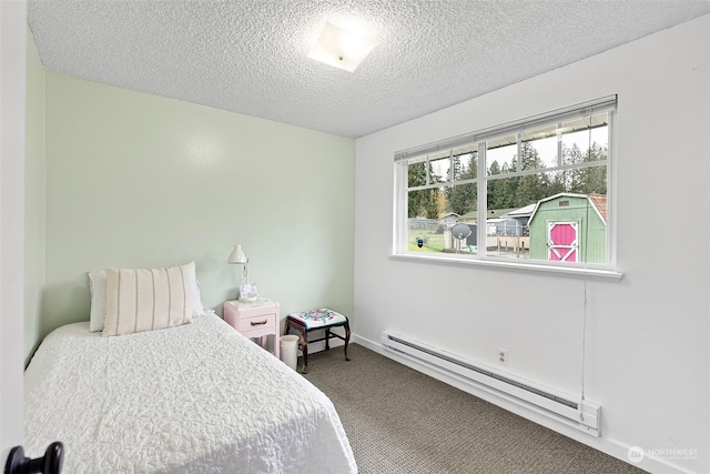 carpeted bedroom featuring a textured ceiling and a baseboard heating unit