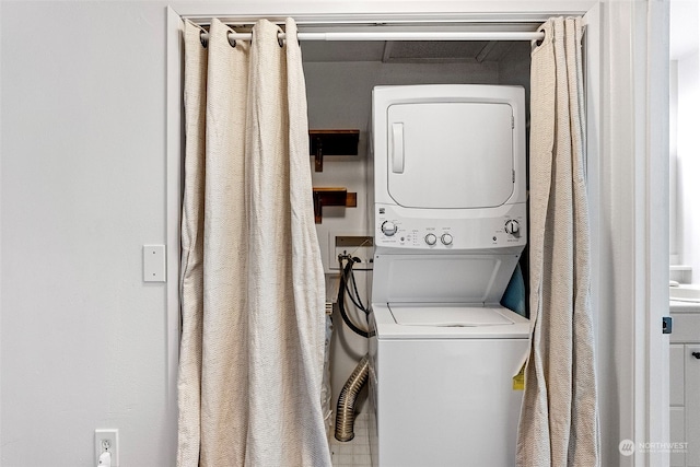 clothes washing area with stacked washer / dryer