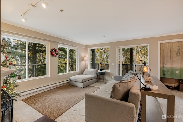 sunroom featuring a baseboard radiator, rail lighting, and a healthy amount of sunlight