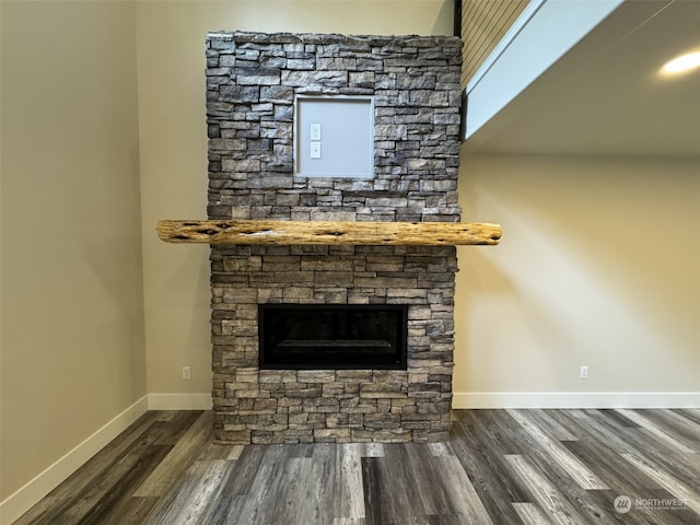 room details with hardwood / wood-style flooring and a stone fireplace