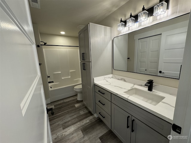 full bathroom with vanity, toilet, shower / bathtub combination, and hardwood / wood-style floors