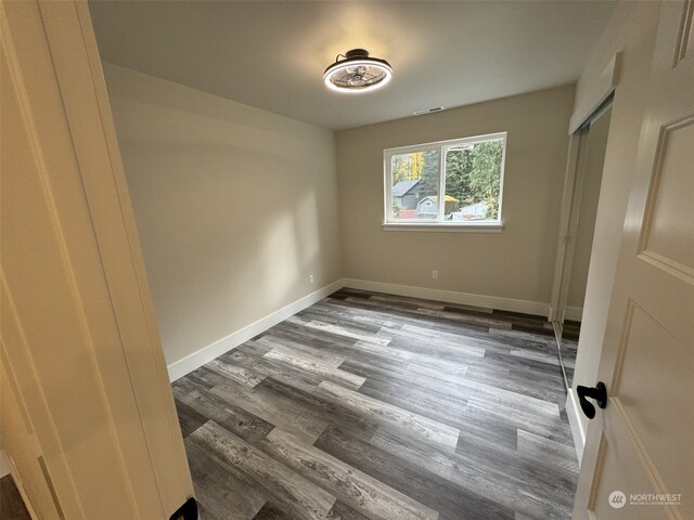 111 Heather Pl, Packwood, WA 98361 - unfurnished bedroom featuring dark wood-style flooring, baseboards, and a closet