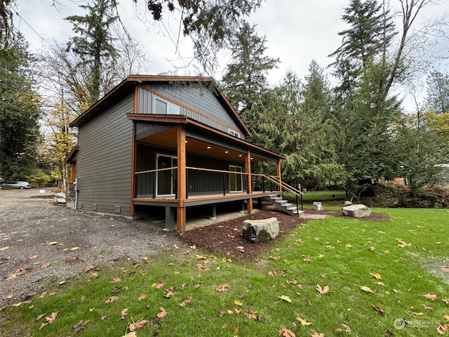 back of property featuring a wooden deck and a yard