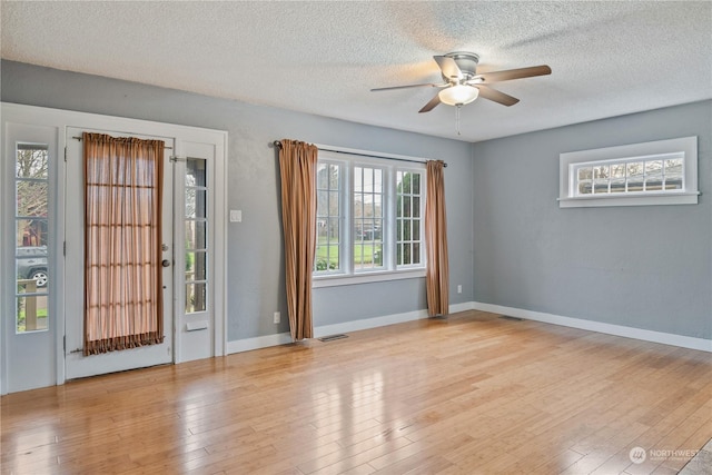 interior space with a textured ceiling, light hardwood / wood-style floors, and ceiling fan