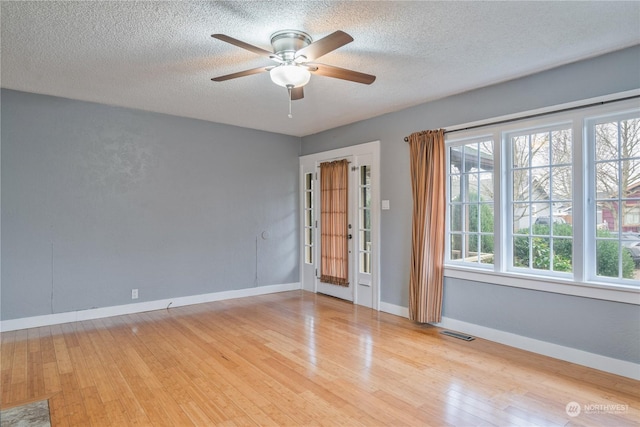 spare room featuring ceiling fan, light hardwood / wood-style floors, and a textured ceiling