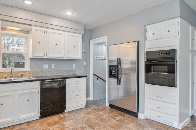 kitchen featuring black appliances, white cabinetry, sink, and a textured ceiling