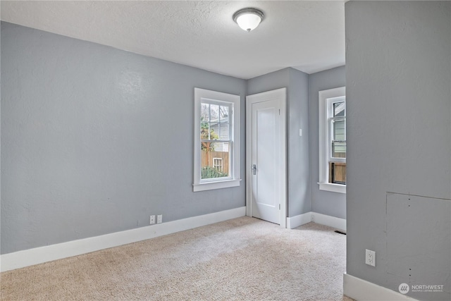 carpeted spare room featuring a textured ceiling