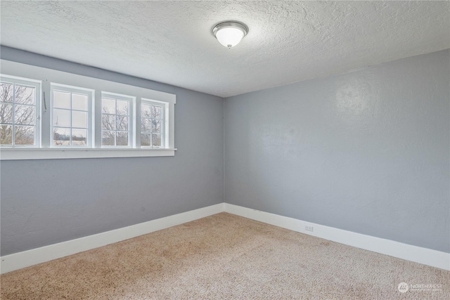 carpeted spare room with a textured ceiling