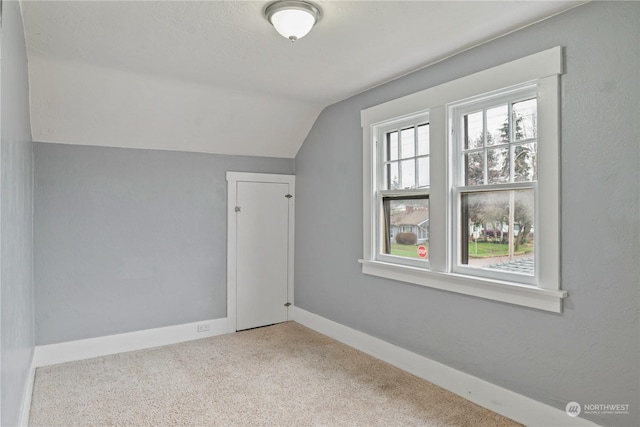 bonus room featuring light carpet and vaulted ceiling