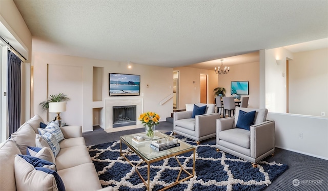 living room with dark colored carpet, a textured ceiling, and an inviting chandelier