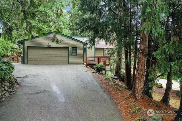 view of front of home featuring a wooden deck and a garage