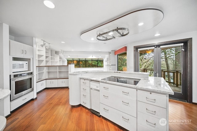 kitchen with stainless steel oven, light stone counters, wood-type flooring, black electric stovetop, and white cabinets