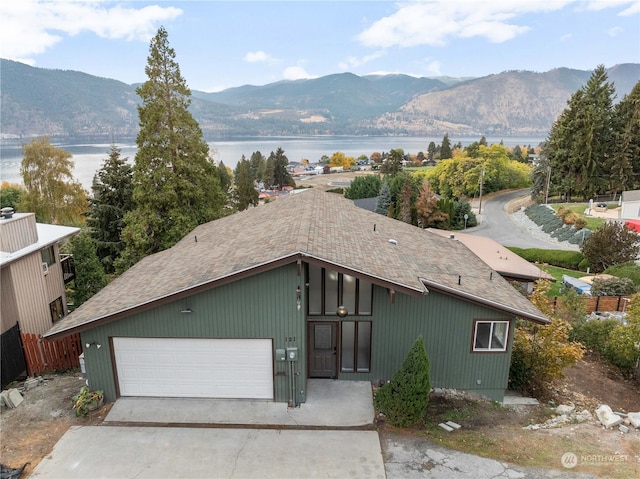 view of front of property with a garage and a water and mountain view