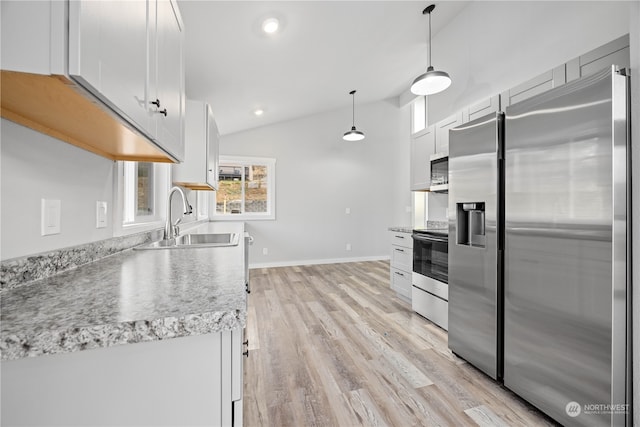 kitchen with white cabinetry, appliances with stainless steel finishes, decorative light fixtures, sink, and lofted ceiling