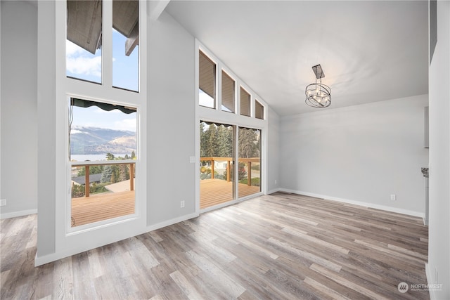 interior space featuring high vaulted ceiling, hardwood / wood-style flooring, and a chandelier