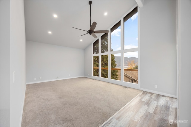 unfurnished room featuring ceiling fan, light hardwood / wood-style floors, a mountain view, and high vaulted ceiling