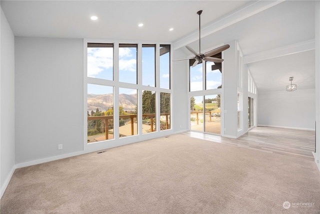 unfurnished living room featuring a mountain view, high vaulted ceiling, and light colored carpet