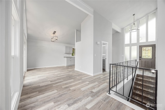 interior space with light hardwood / wood-style flooring, a chandelier, and a high ceiling