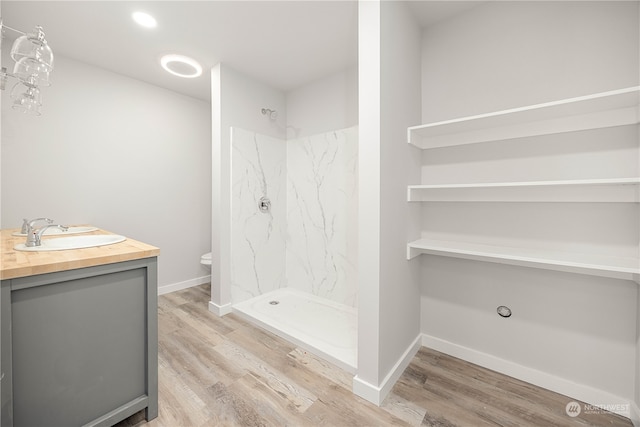 bathroom featuring toilet, vanity, wood-type flooring, and walk in shower