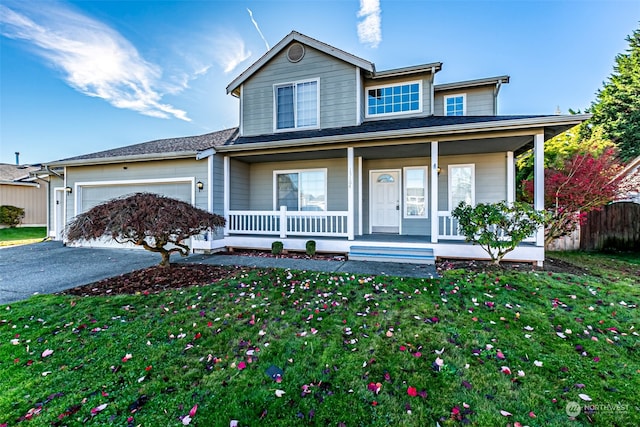 view of front of home with a front yard, a garage, and covered porch